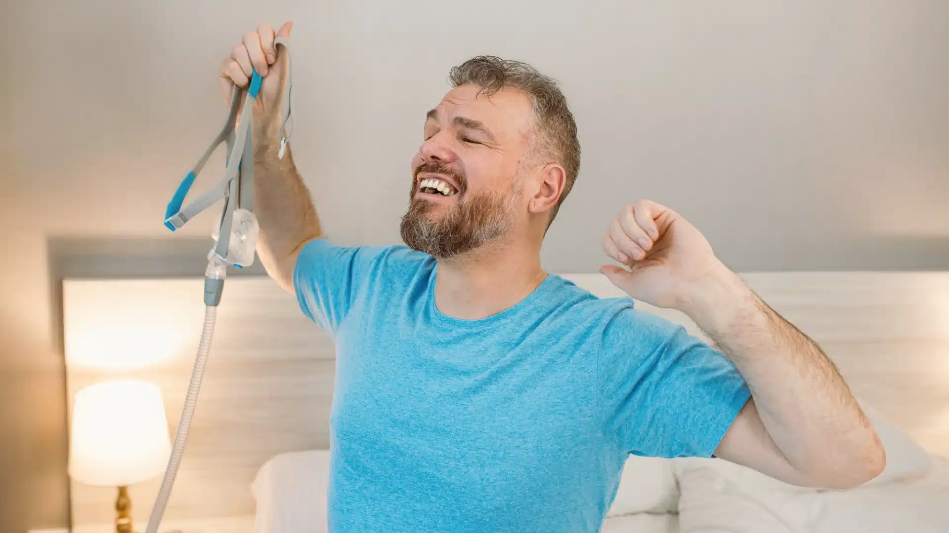 Health Hub 53 Happy man waking up refreshed after using CPAP machine for sleep apnea treatment