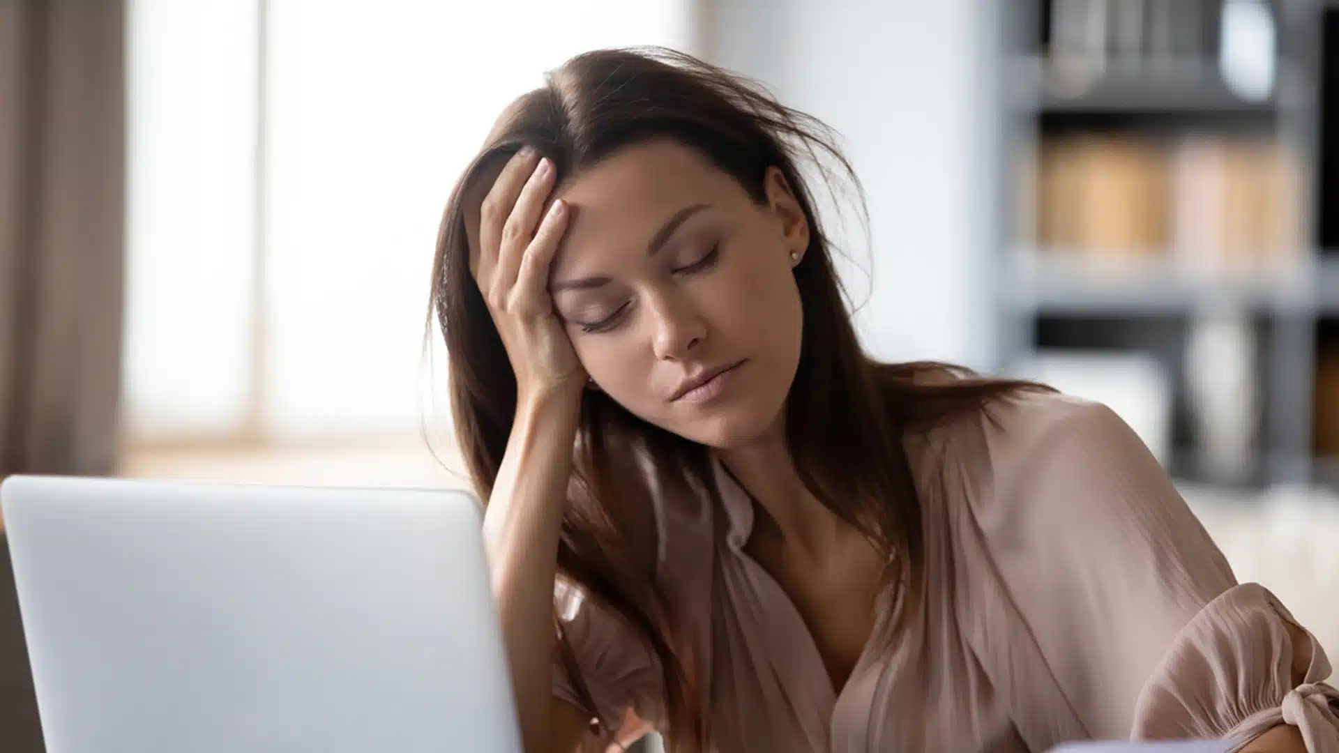 Health Hub 19 Tired woman struggling with fatigue and lack of sleep while working on laptop