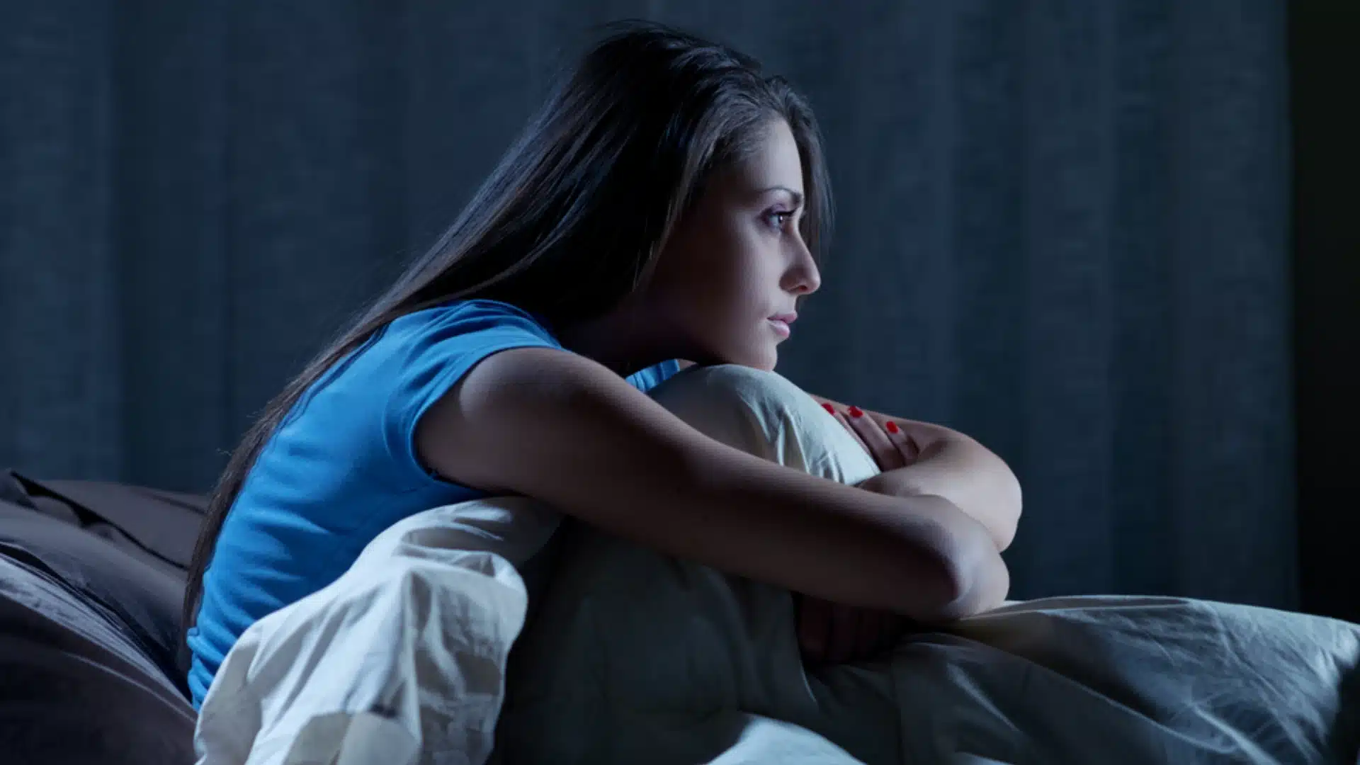 Health Hub 51 Woman struggling with insomnia sitting awake in bed at night