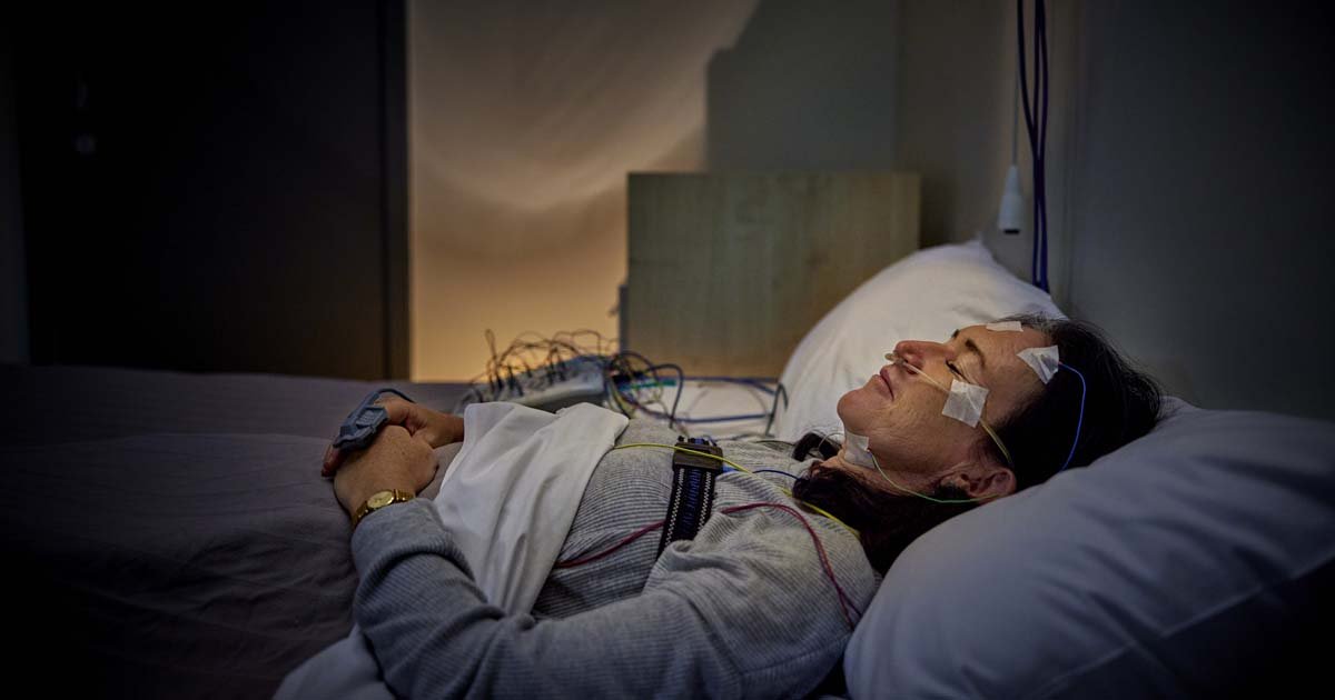 Health Hub 5 Woman undergoing overnight sleep study with electrodes attached for polysomnography test