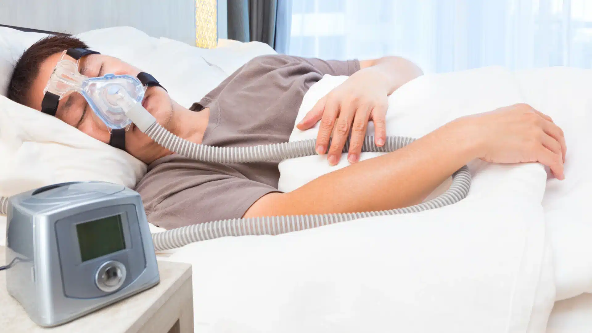 Health Hub 43 Man sleeping with CPAP machine and face mask for sleep apnea treatment