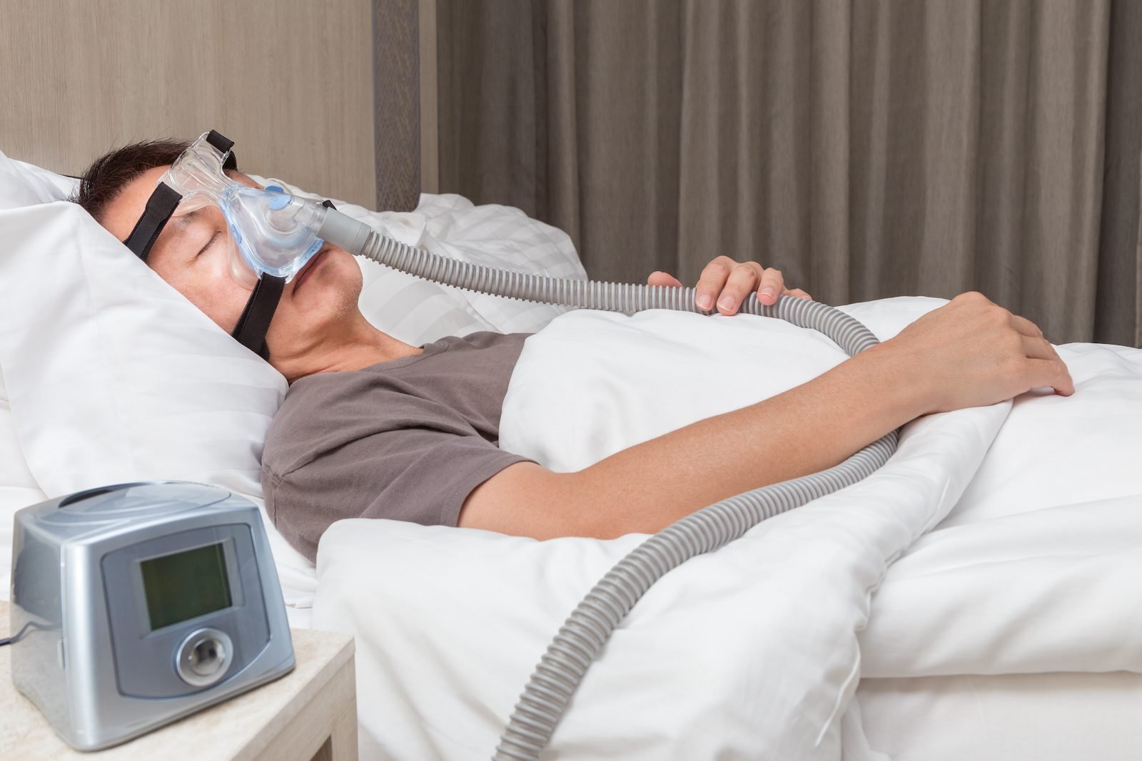 Health Hub 37 Man sleeping with CPAP machine and nasal mask for obstructive sleep apnea therapy