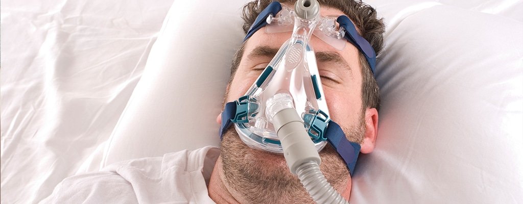 Health Hub 36 Man sleeping with CPAP face mask for obstructive sleep apnea treatment