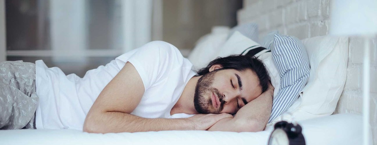 Health Hub 40 Man sleeping peacefully in bed at night showing healthy rest and relaxation