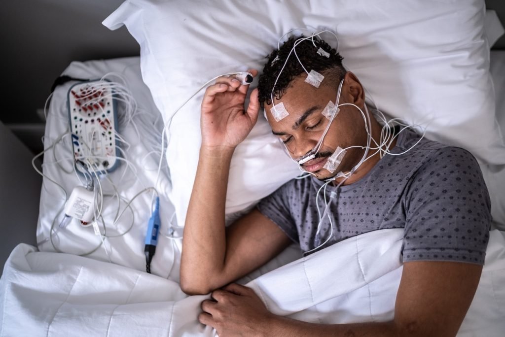 Health Hub 33 Man in sleep study with electrodes for sleep apnea test